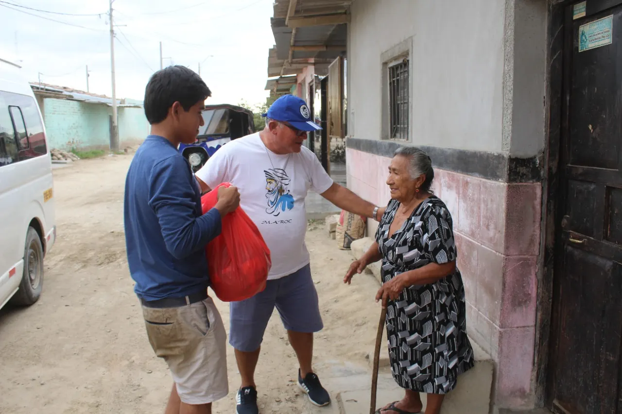 Un voluntario salesiano conversa con una señora en la calle